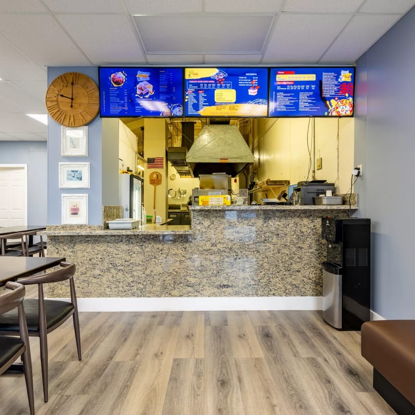 Interior of Garlex Pizza & Ribs, showing the order counter, kitchen, and dining area.