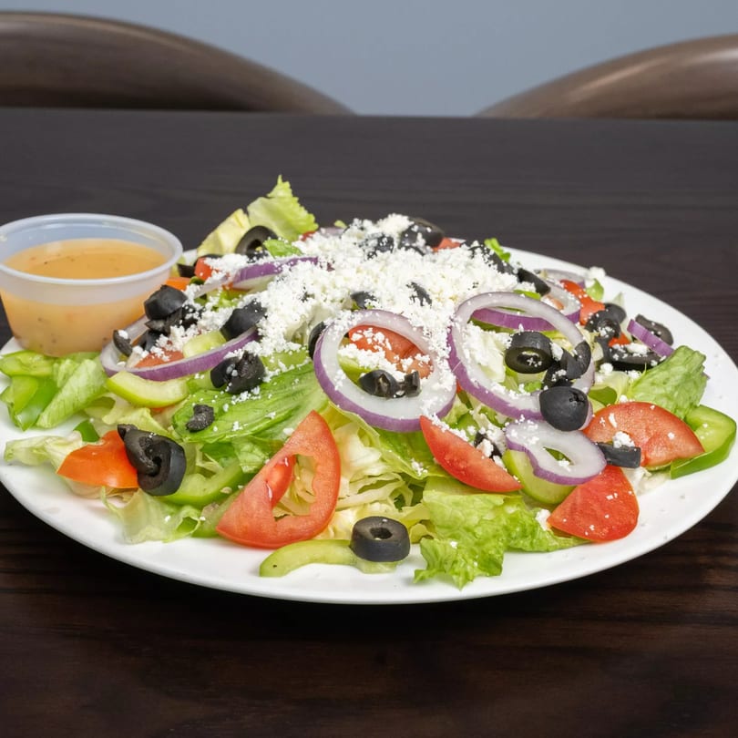 Garlex Pizza & Ribs' Italian salad with lettuce, tomatoes, onions, olives, and feta cheese.